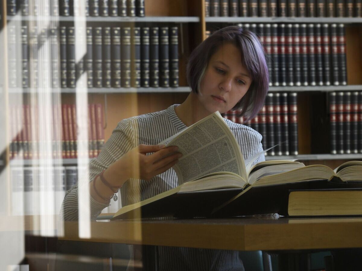    Девушка читает книгу в библиотеке | © РИА Новости / Кирилл Каллиников