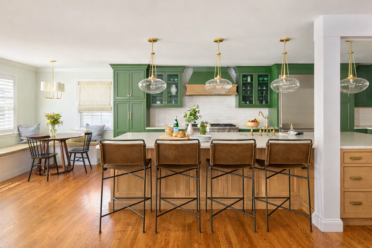 Кухня с оливковыми фасадами, светлой каменной столешницей и деревянным полом