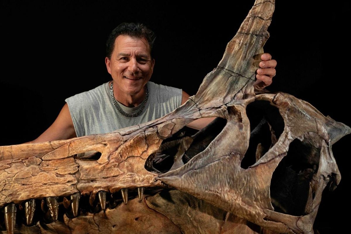    Пол Серено позирует с реконструированным черепом спинозавра. / phys.org