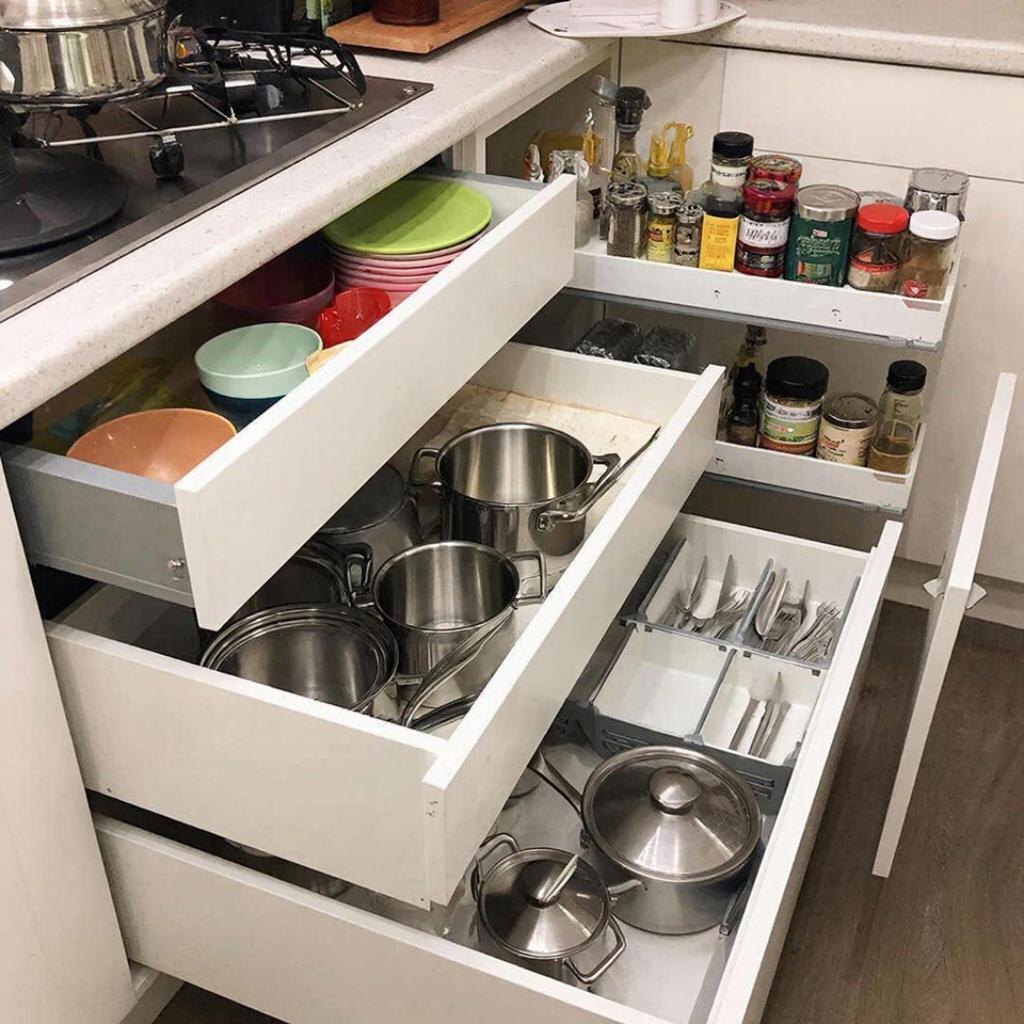 Организация хранения в маленькой кухне: выдвижные ящики разной высоты и узкий пенал для специй.