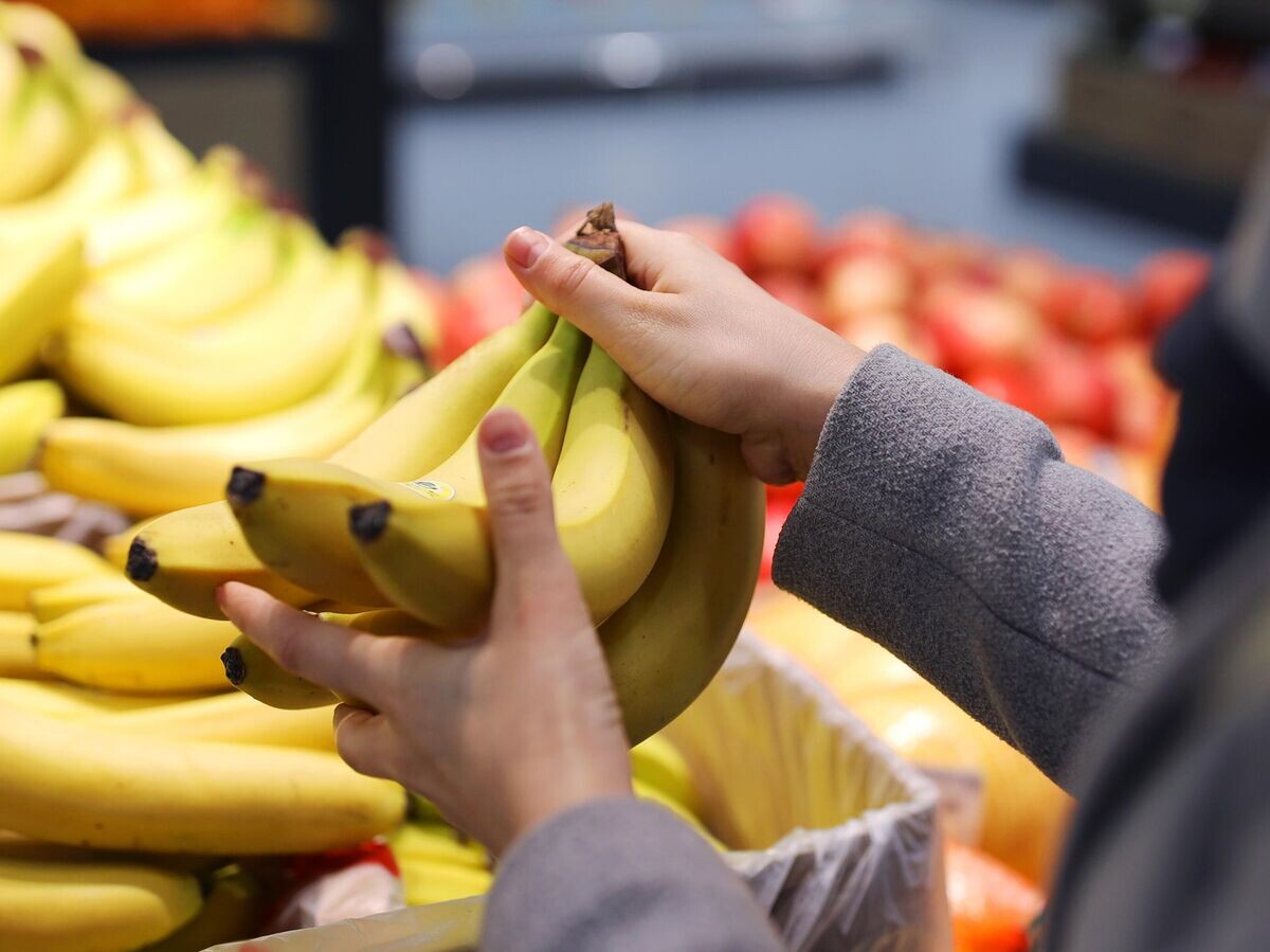    Женщина выбирает бананы в магазине © РИА Новости . Виталий Тимкив