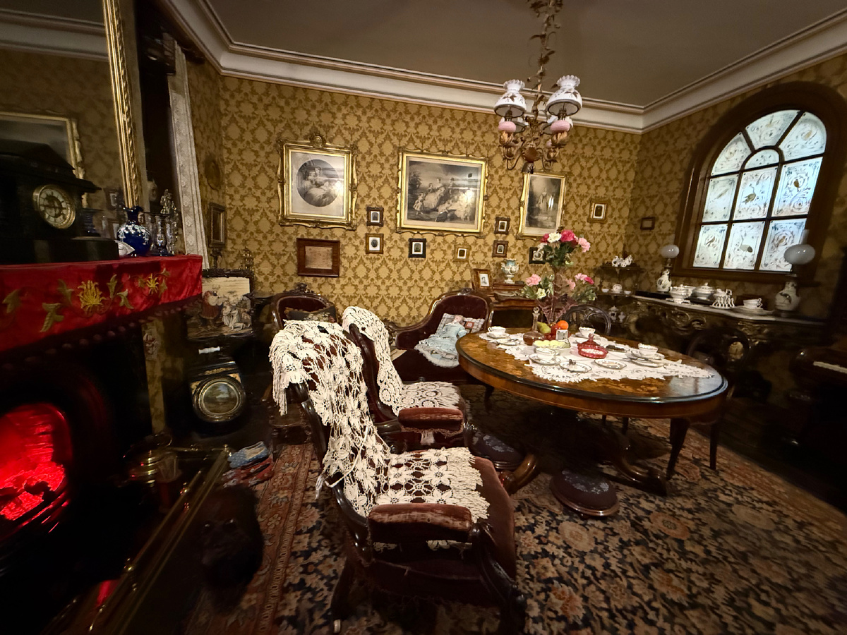 Гостиная 1872 года. Из дневника леди Мэри, хозяйки гостиной: "Массовое производство на фабриках делает роскошь доступной для всех нас, и я наполнила комнату модной мебелью, украшениями и всевозможными безделушками. Чарльз говорит, что она выглядит немного тесноватой, но сейчас такова мода. Мы по-прежнему можем позволить себе только одну прислугу, горничную на все случаи жизни. Она хорошо справляется со всей тяжелой работой, учитывая, что ей всего 15 лет.". Фотография из личного архива. 