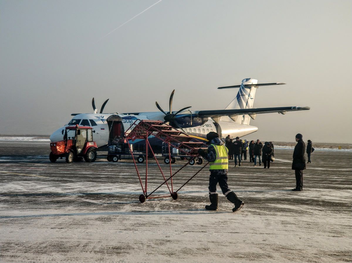 После посадки пассажиры идут к зданию аэропорта, сотрудники осуществляют выгрузку багажа