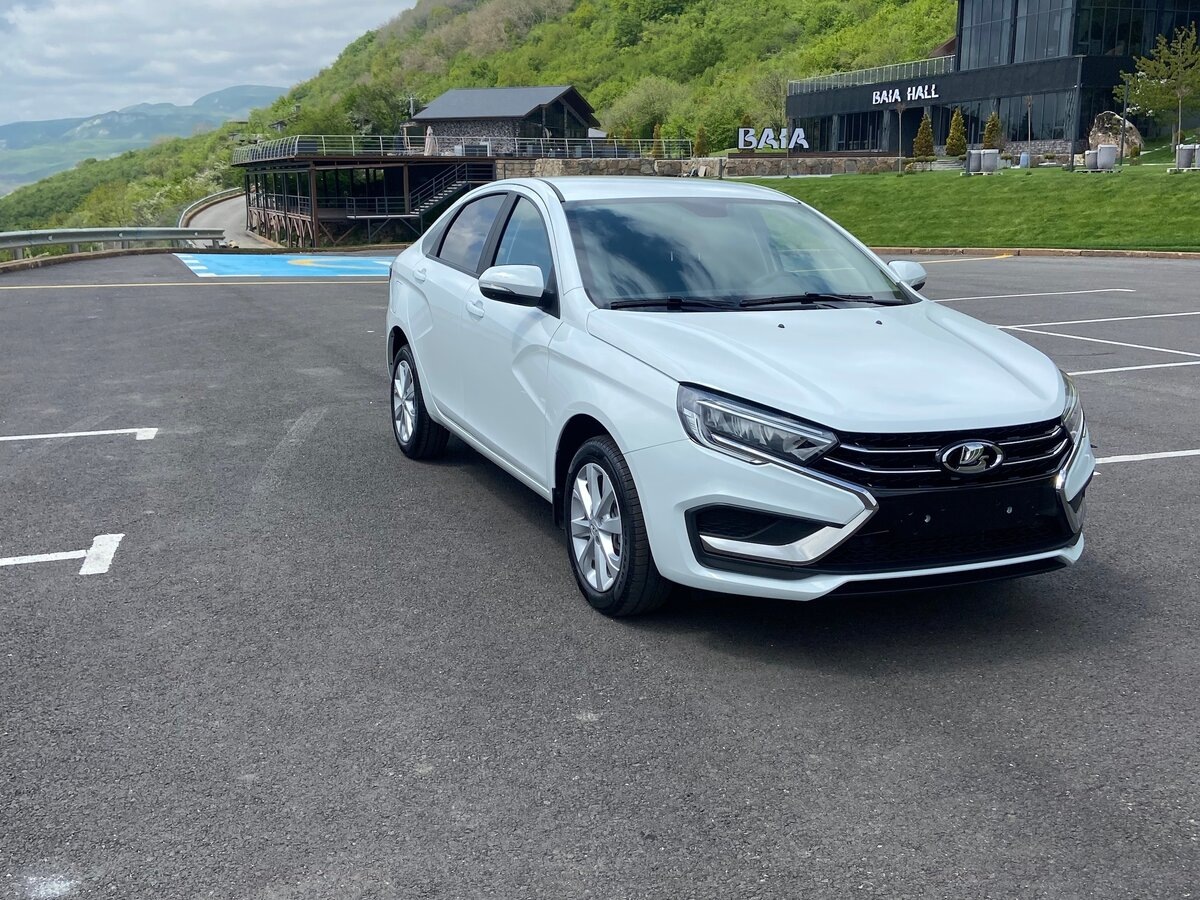 Три часа за рулём — и я понял, что всё это время недооценивал её.
Не ждал откровений. Брал машину на вечер просто потому что такси в пятницу стоило как перелёт в Сочи. Открыл приложение, нашёл ближайший автомобиль, подошёл.
Lada Vesta. Белая. Слегка уставшая снаружи, но живая.
Сел. И поехал. А потом долго думал.