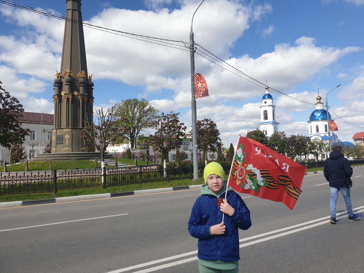Юный патриот на фоне стеллы Город воинской славы, движемся смотреть парад Победы