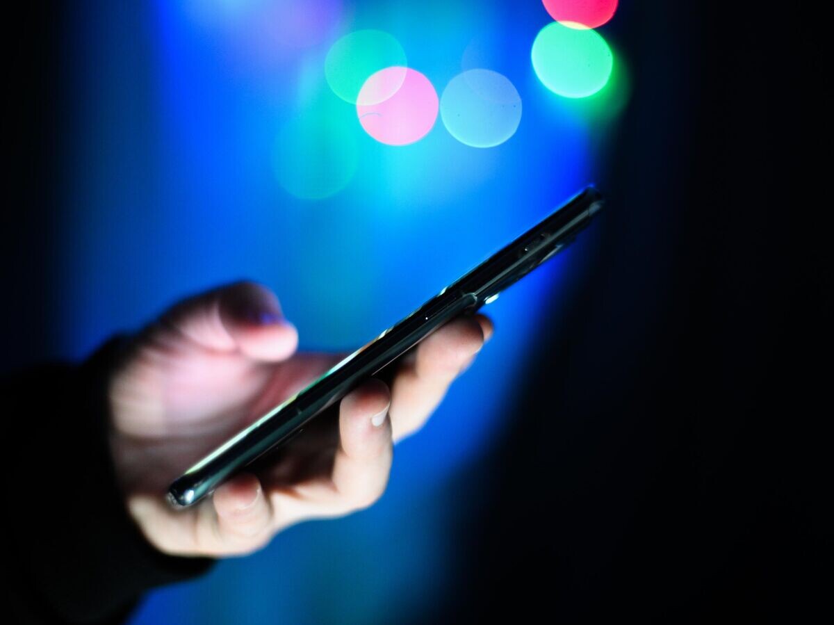    Мужчина держит в руках мобильный телефон | © РИА Новости / Владимир Астапкович