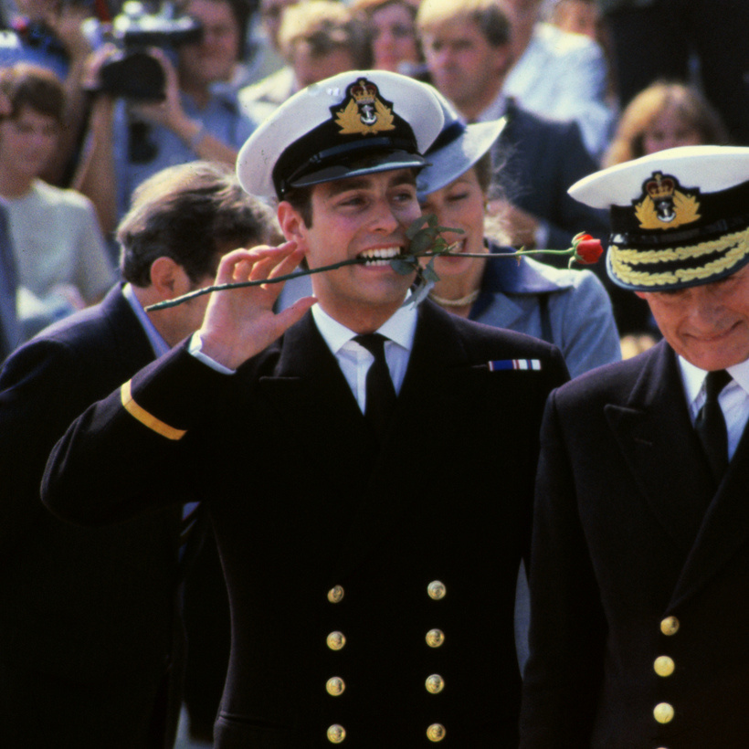 Принц Эндрю с розой во рту вместе с матерью и отцом, королевой Елизаветой и принцем Филиппом, возвращается с Фолклендских островов на борту корабля «Инвинсибл». Принцесса Анна стоит позади принца Эндрю.