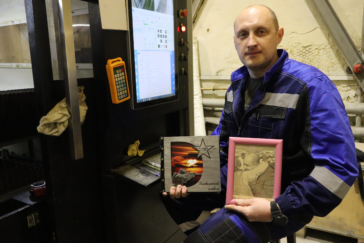 Подзолко на рабочем месте. В руках — дембельский альбом и памятное фото в рамке. / ФОТО: ЕЛЕНА АРЦИМОВИЧ