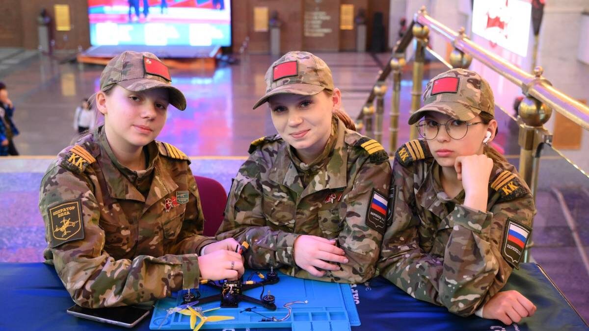    Участницы Всероссийской военно-патриотической игры «Зарница 2.0» ученицы Любучанской школы города Чехова Ксения Крючкова, Елизавета Шидловская и Елизавета Суслова работают над сборкой механизма квадрокоптера / Фото: Пелагия Замятина / Вечерняя Москва