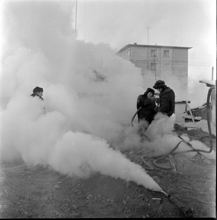 Рабочие смягчают мерзлый грунт паровым оборудованием для строительных работ