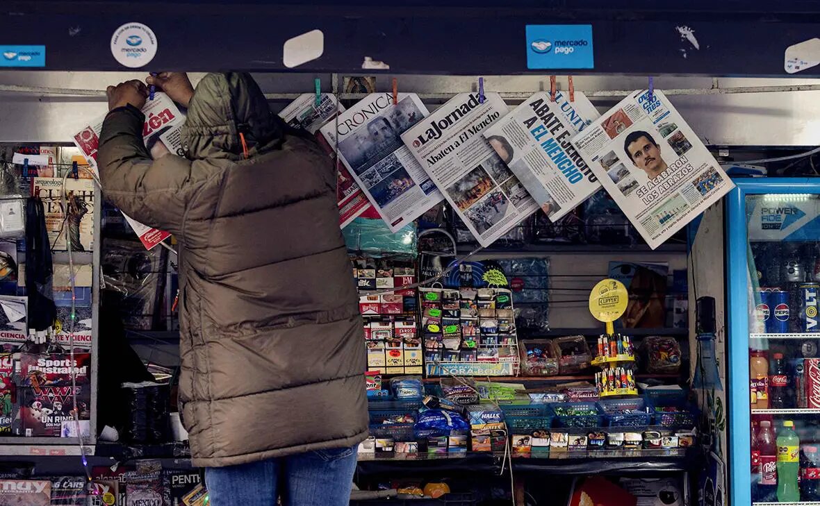    Продавец киоска развешивает газеты, освещающие обстановку в Мексике после убийства Немесио Осегеры Сервантеса (Эль Менчо), Мехико Фото: Quetzalli Nicte-Ha / Reuters Илья Леонов