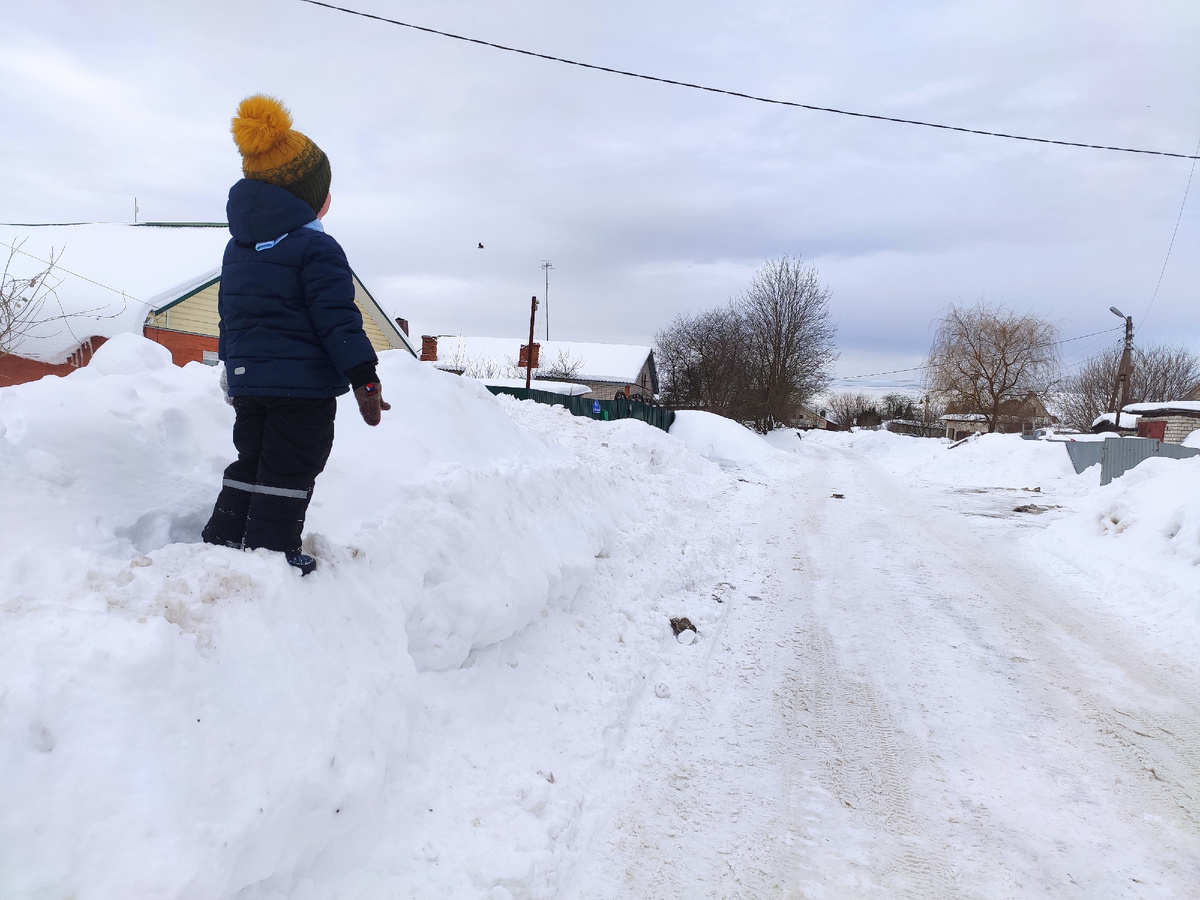 Дети не по дороге ходят, а по огромным снежным горам вдоль дороги 😁 снежные сугробы больше заборов.
