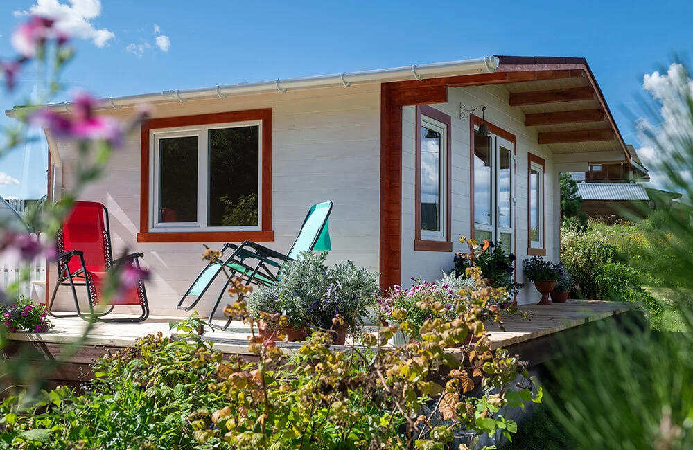 Для сборки небольшого дачного домика «из коробки» не нужно быть профессиональным строителем. К вам на участок привозят комплект деталей для сборки, который помещается на одной паллете, в ней есть коробка с крепежом. В дополнительной комплектации «комфорт» есть окна и двери. Водостоками и кровельным покрытием, например, гибкой черепицей, постройку можно укомплектовать у представителей компании. Но так или иначе, два-три выходных — и у вас готовый дом: можно заносить мебель.