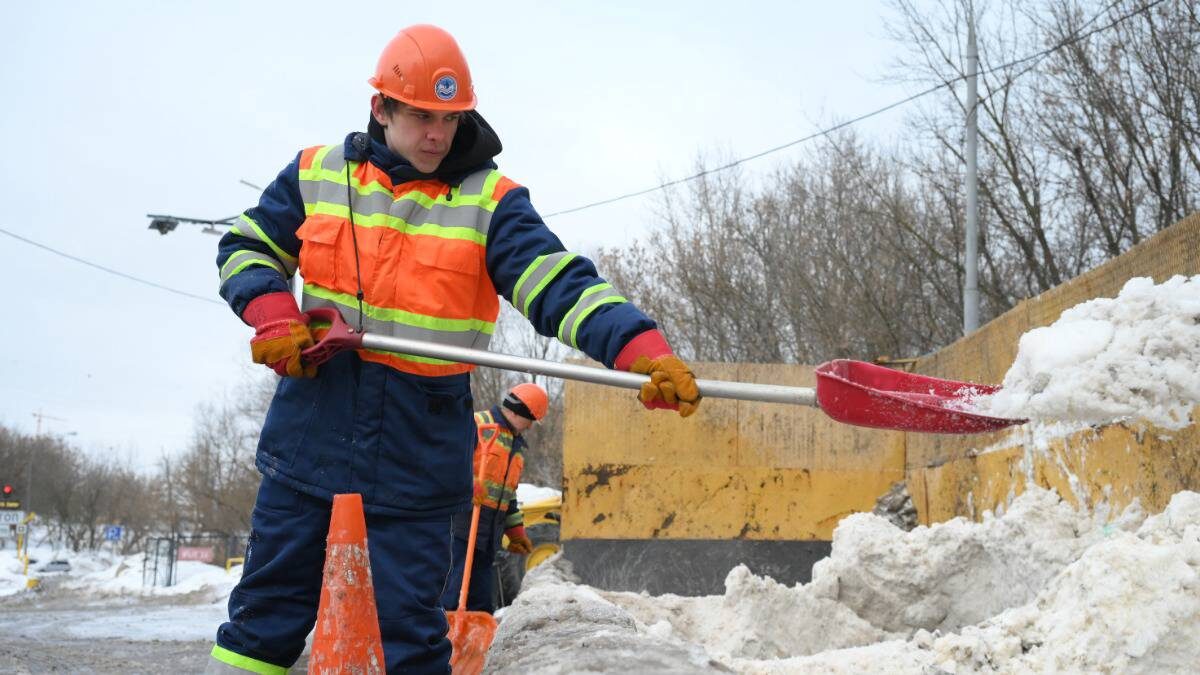    Рабочий Никита Буянов загружает снег на снегосплавном пункте / Фото: Пелагия Замятина / Вечерняя Москва