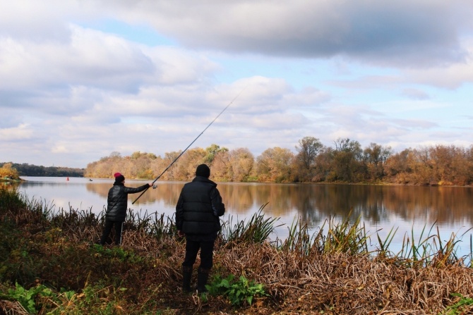 Рыбак на берегу реки рядом с загородным отелем