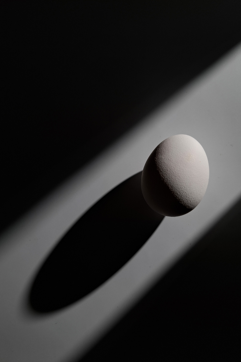 Свет светит сквозь преграды, я напомню, чем меньше источник света, тем жестче свет (тени имеют более четкие границы) Расстояние до объекта съемки влияет так же, чем дальше источник света, тем он будет меньше относительно объекта съемки, следовательно  жестче. Ну и высота, чем ниже свет, тем длиннее тени. Такая фотография яйца выглядит интересней, не правда ли?