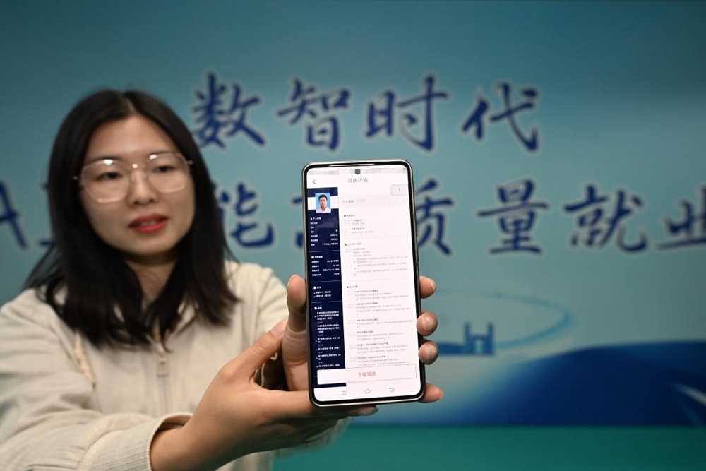    Сотрудница Тяньцзиньского университета иностранных языков показывает резюме соискателя работы, сгенерированное с помощью ИИ. / Фото: Синьхуа