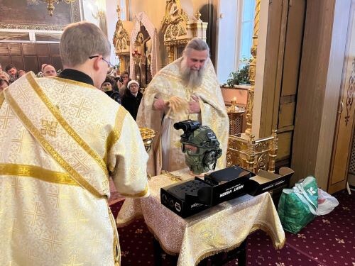 Протоиерей Виталий Кулешов освещает прибор ночного видения в храме