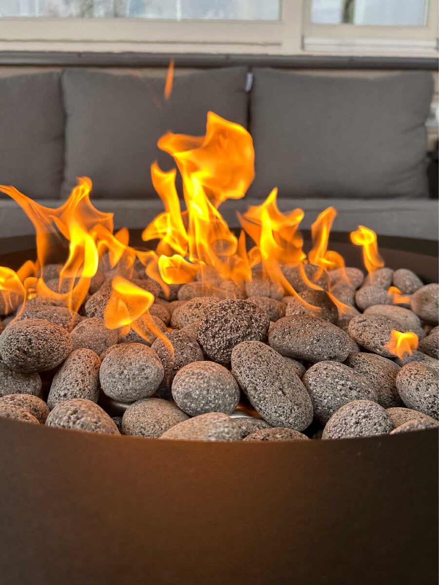 Пламя сквозь лавовый камень в уличном газовом камине ANGELSFIRE, работающем на пропане.