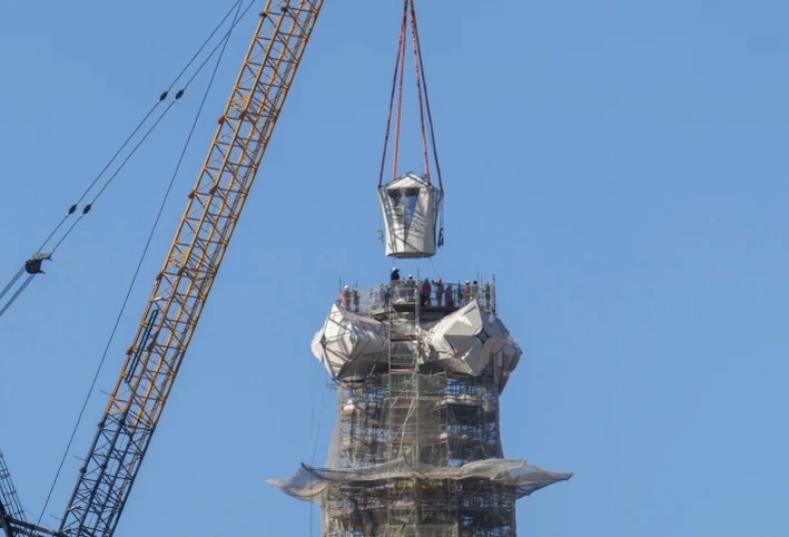 Верхняя часть 17-метрового четырехлучевого креста опускается, завершая строительство башни Иисуса Христа.