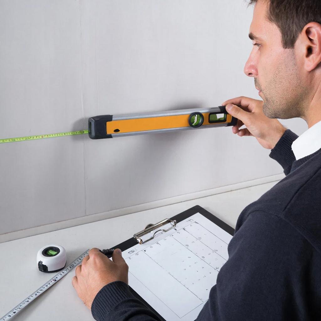  Мастер выполняет профессиональный замер кухни лазерным уровнем.