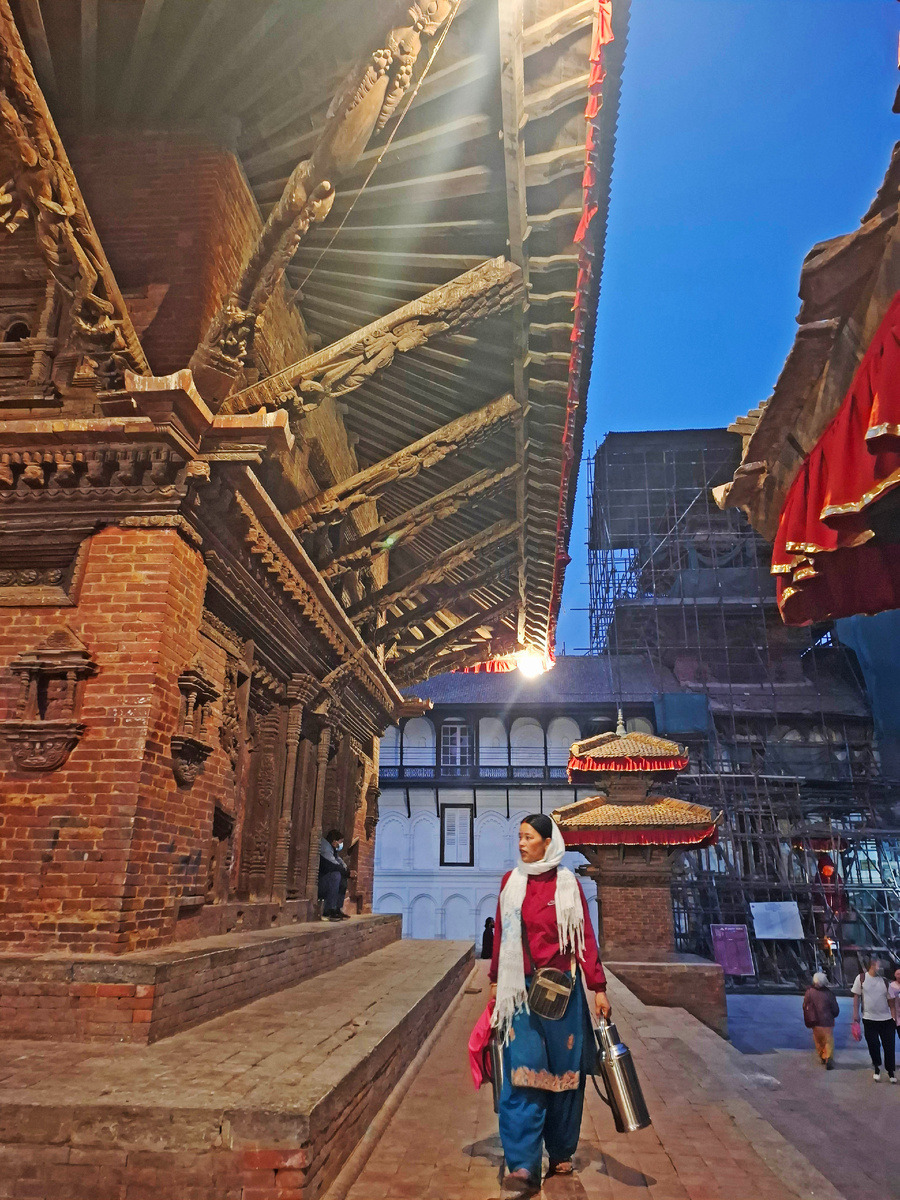 Белая стена принадлежит Хануман Дхока (Hanuman Dhoka). Обратите внимание на оранжевое «лицо» за строительными лесами. Фото автора.