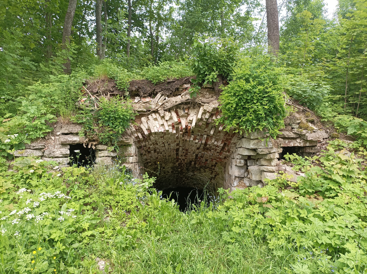 Вход в склеп с разрушенной кирпичной кладкой.