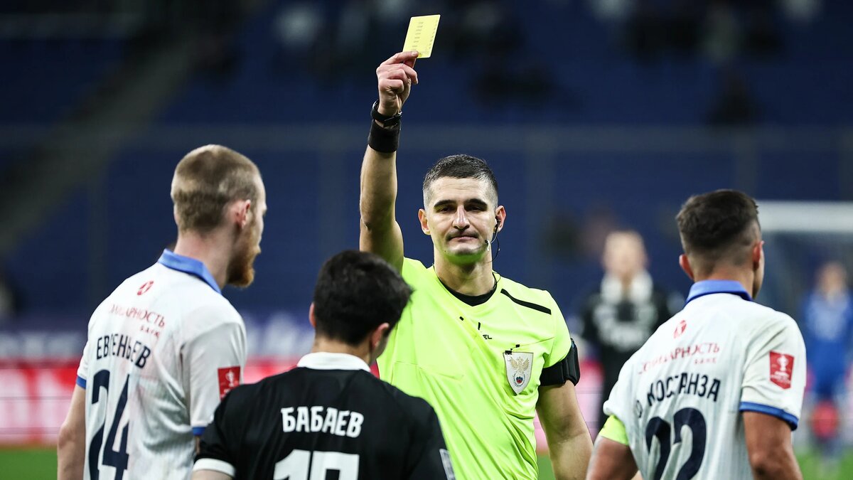   Михаил Терещенко / ТАСС- Кубок России по футболу: «Динамо» - «Крылья Советов». Главный судья матча Владислав Целовальников показывает желтую карточку Ульви Бабаеву («Динамо») во время матча. Москва, Россия, 22 октября 2025 года