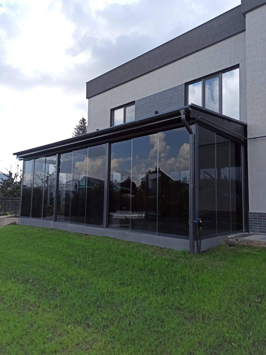 Современное безрамное остекление террасы в частном доме.