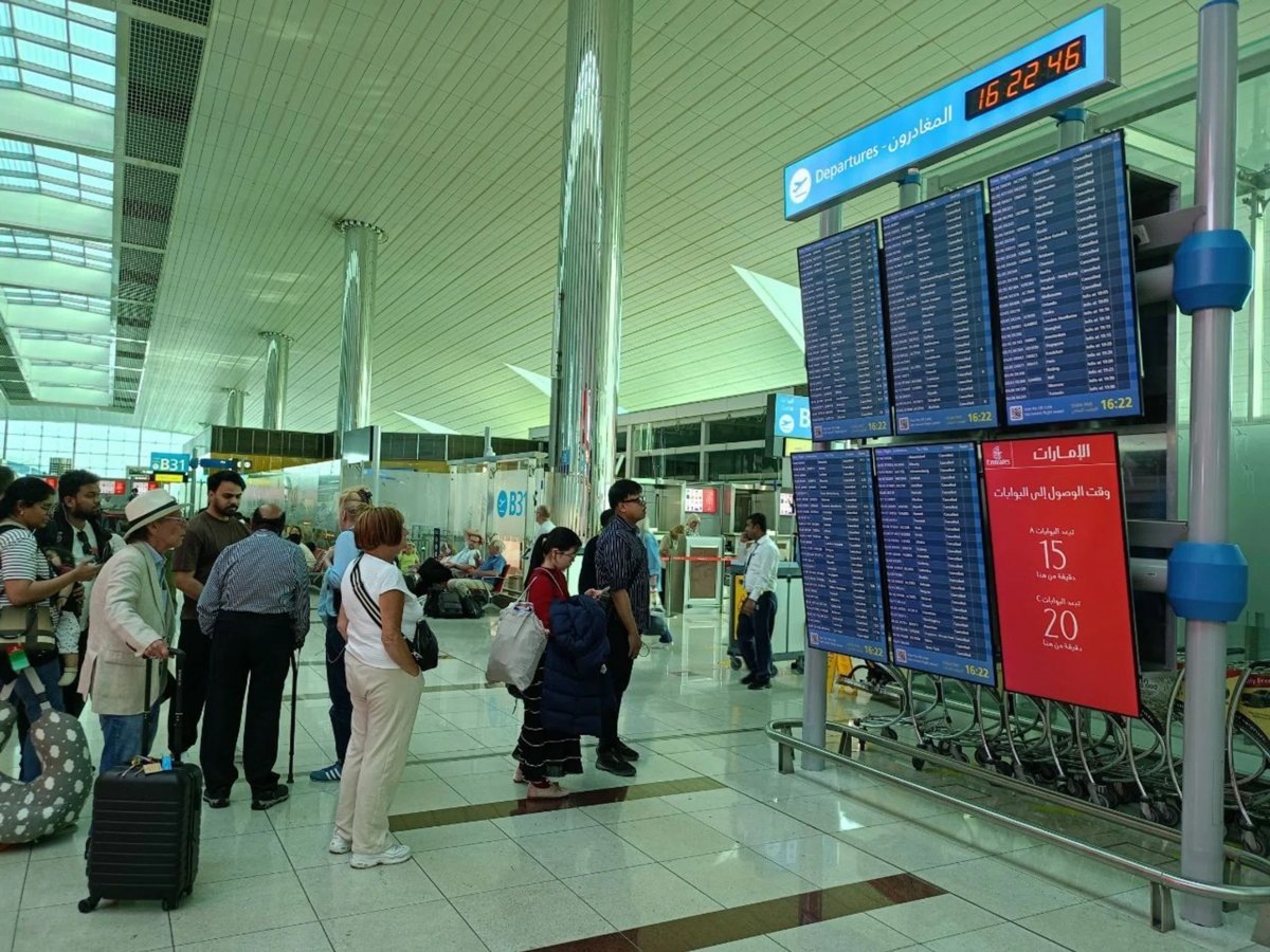    Туристы проверяют свои рейсы у информационных табло