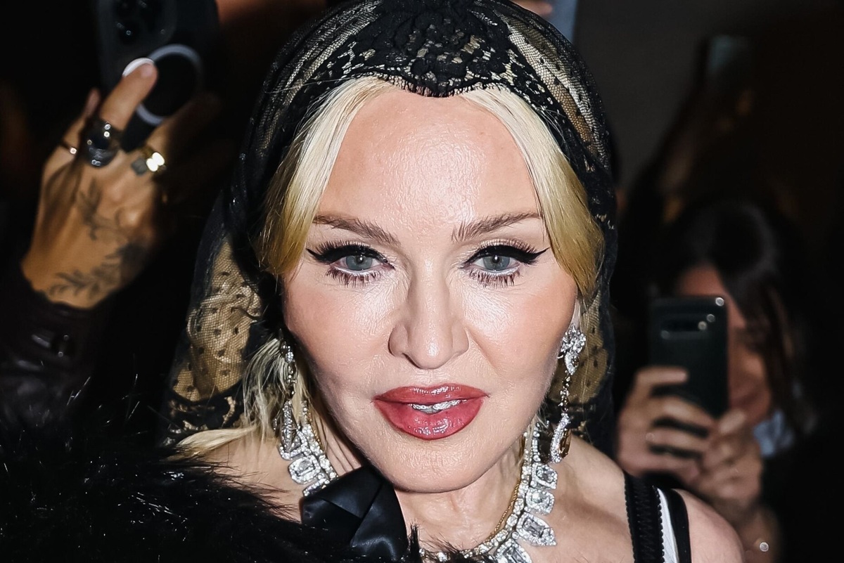     Мадонна в корсетном мини-платье и синих латексных перчатках появилась на модном шоу в Милане