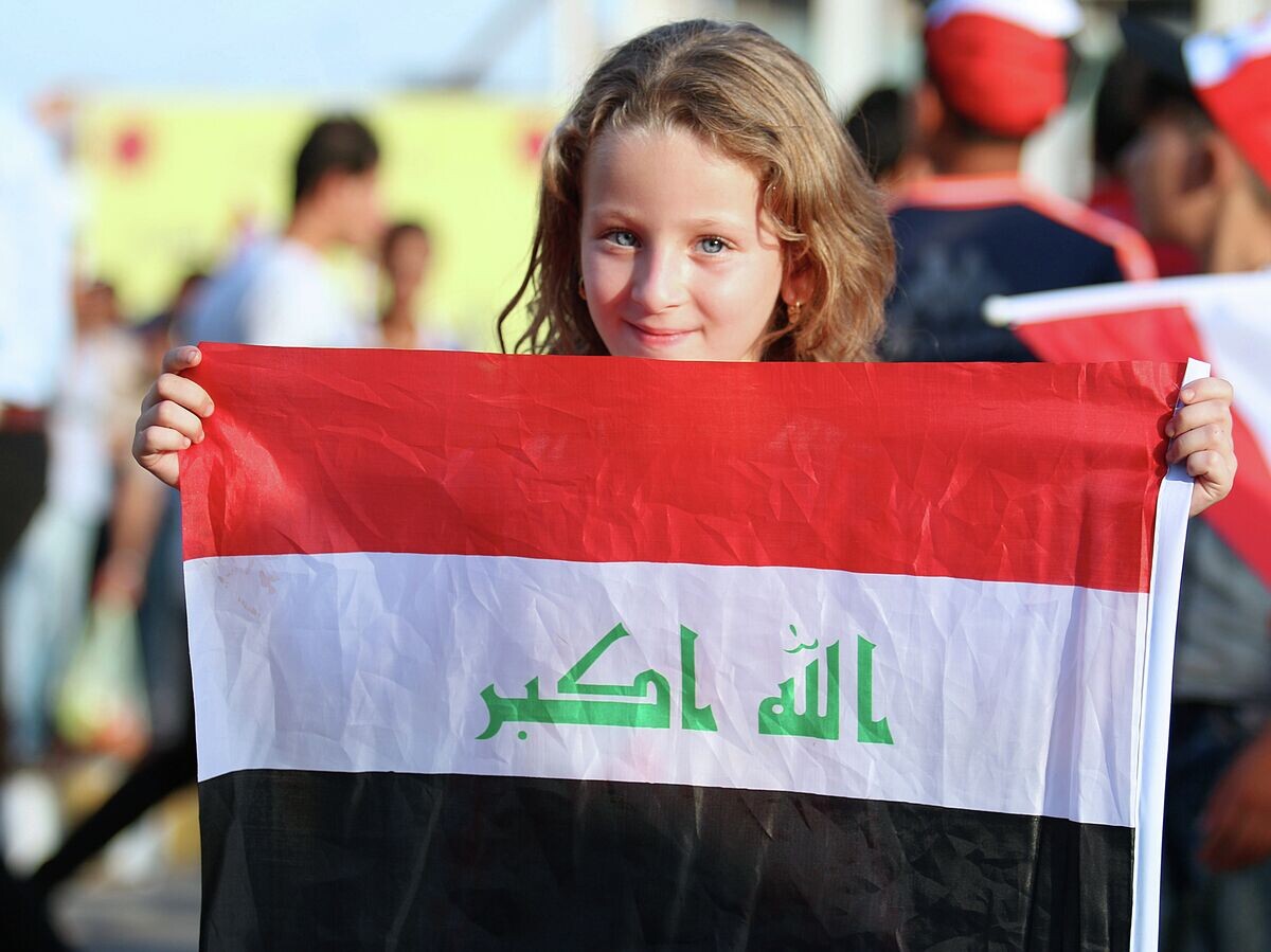    Девочка с национальном флагом Ирака© AFP / Haidar Mohammed Ali