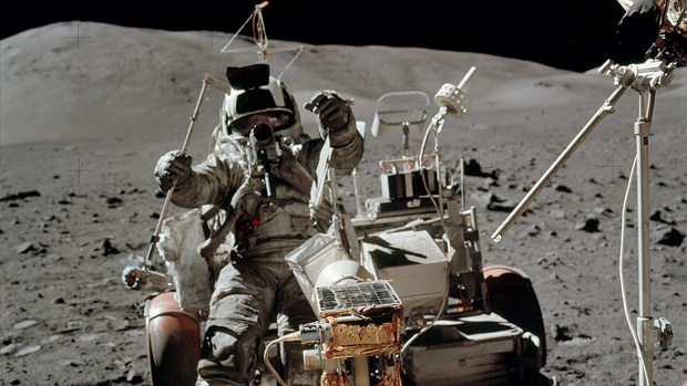 Луноход "Аполлон-17": Шмитт запрыгивает на сиденье лунохода LMP. В правой руке у него пробоотборник LRV. Устройство для транспортировки сейсмических зарядов установлено за сиденьем Сернана, прямо перед "граблями" (NASA).