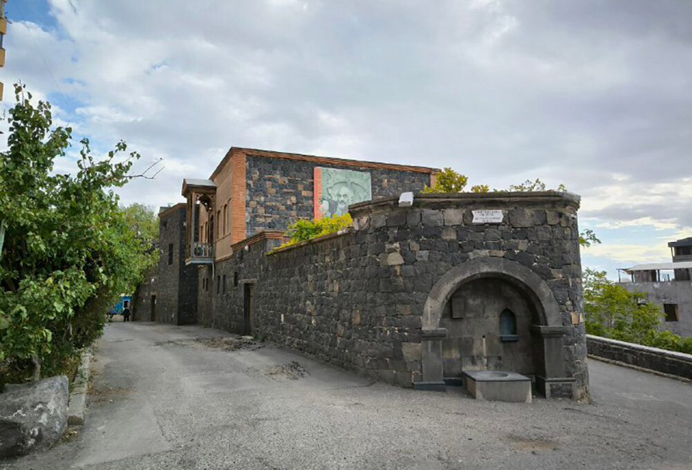 Дом построен из двух видов туфа: розового и чёрного, которые будто делят постройку пополам. Фасад украшает большой фотопортрет Сергея Параджанова. Фото: Алина Краснова