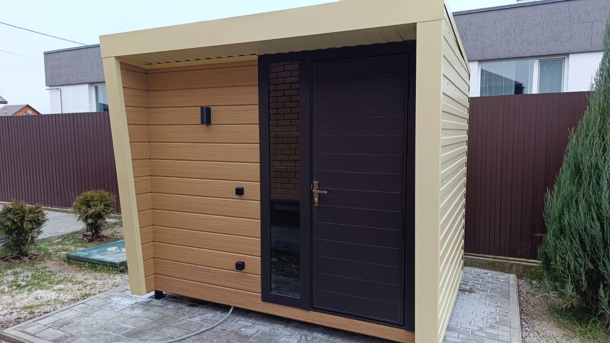 Хозблок с односкатной крышей и нашей стандартной дверью. Лицевая стенка обшита стальным сайдингом.