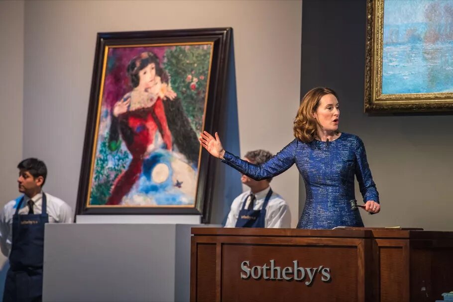 Переполненный аукционный зал Sotheby’s — картина на стенде, аукционист в напряжении