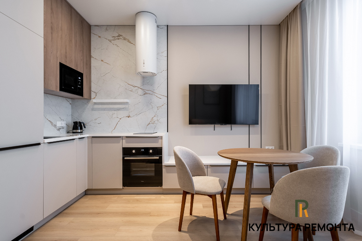 Кухня‑гостиная объединяет зону отдыха с диваном и кухонный блок