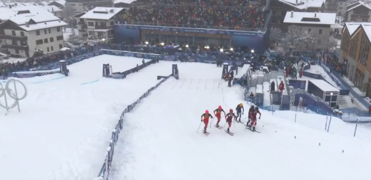 На старте спортсмены бегут на лыжах в гору. Кадр из трансляции "Окко Спорт"