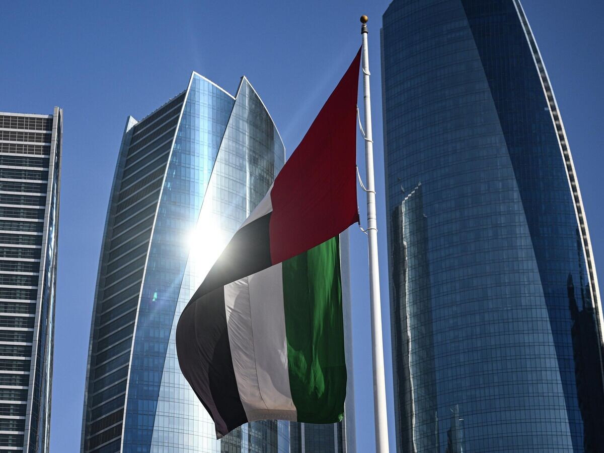    Флаг Объединенных Арабских Эмиратов на фоне небоскребов Абу-Даби | © РИА Новости / Кирилл Зыков