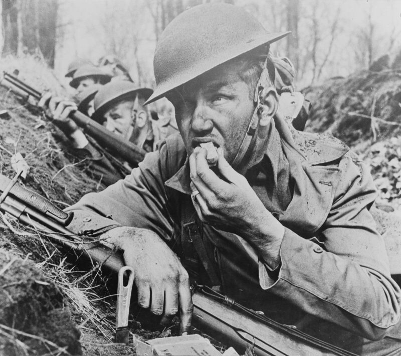 Американские солдаты в окопе во время обстрела. Солдат на переднем плане подносит ко рту сухарь или галету.

Эта фотография использовалась для агитационных плакатов в США «Food from the small farm to the fighting front» (Еда с маленькой фермы для сражающегося фронта).