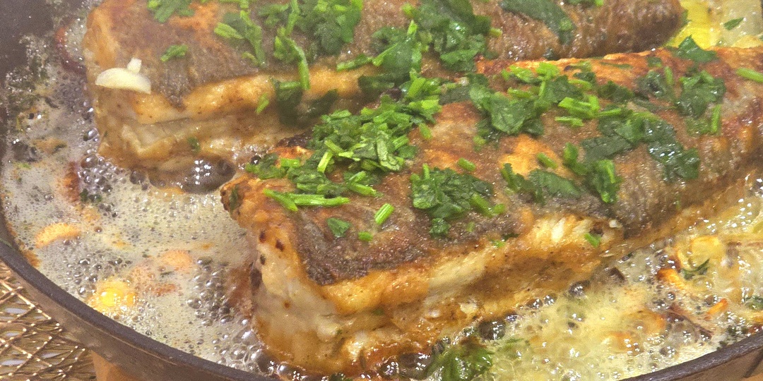 Сибас целой рыбой на сковороде со сливочным маслом, чесноком и пряными травами