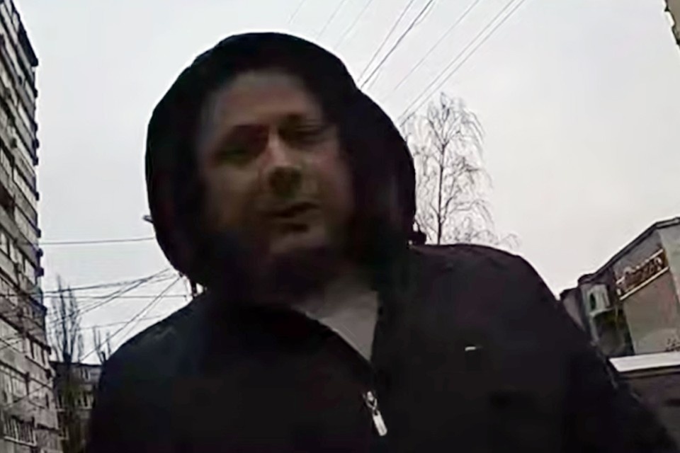    В центре кадра мужчина в капюшоне. Его только что вытащили из-за руля машины сотрудники украинского территориального центра комплектования