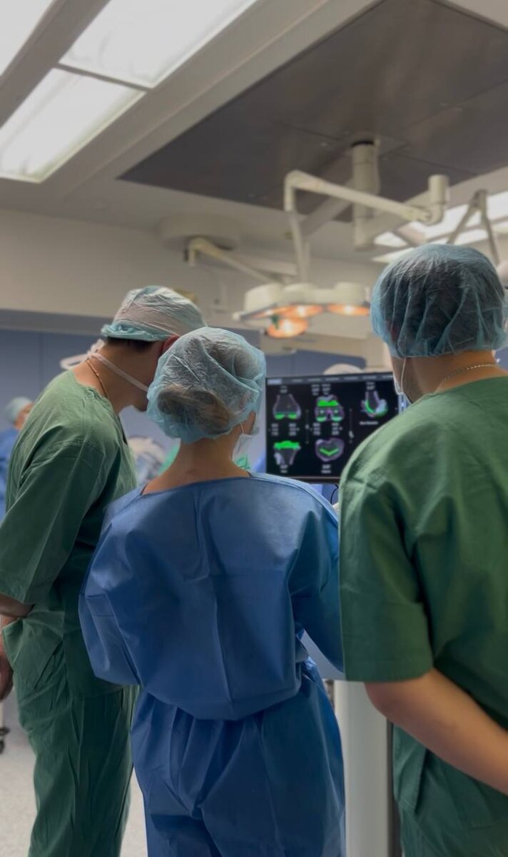 Робот МАКО готовится к работе. Специалисты занимаются его настройкой.