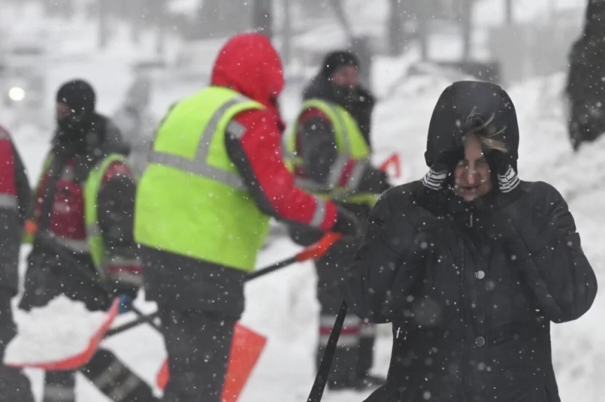    Девушка идёт по улице во время снегопада в Москве.