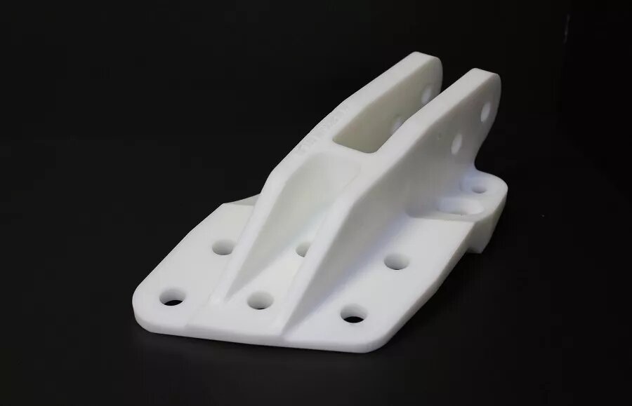 Сложный кронштейн из температуростойкой высокопрочной смолы выдерживает повышенные механические нагрузки и может эксплуатироваться при температурах до 120 °C | Изделие напечатано на SLA‑принтере российского бренда CUBRUS