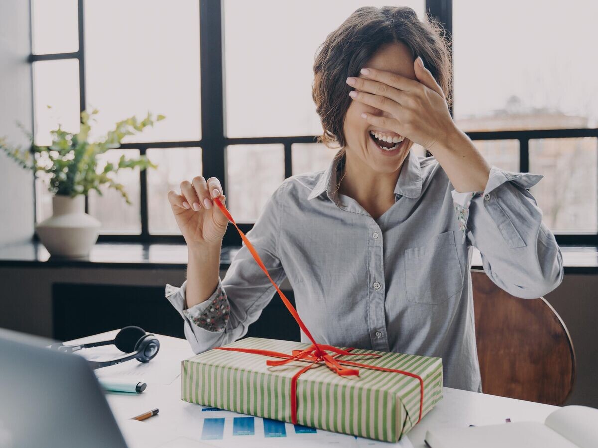    Девушка открывает коробку с подарком | © iStock.com / Viorel Kurnosov