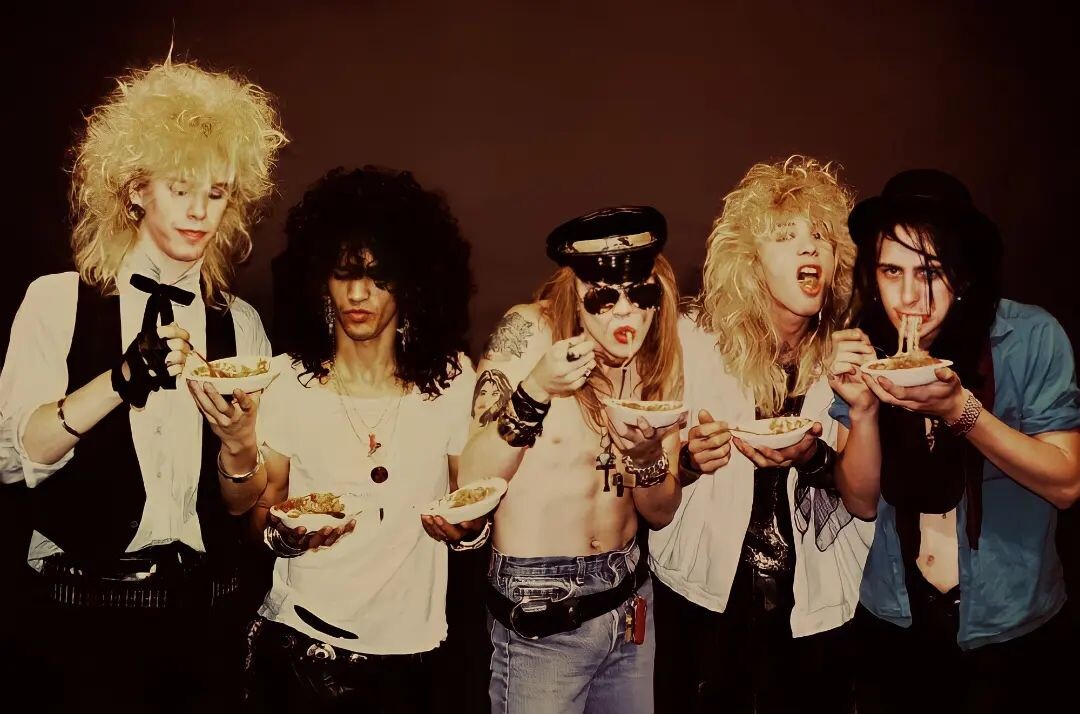 Оригинальный состав рок-группы Guns N' Roses во время промо-фотосессии в октябре 1985 года. Фотограф Джек Лю заснял музыкантов, поедающих спагетти, что стало отсылкой к их жизни в Голливуде до прихода большой славы.