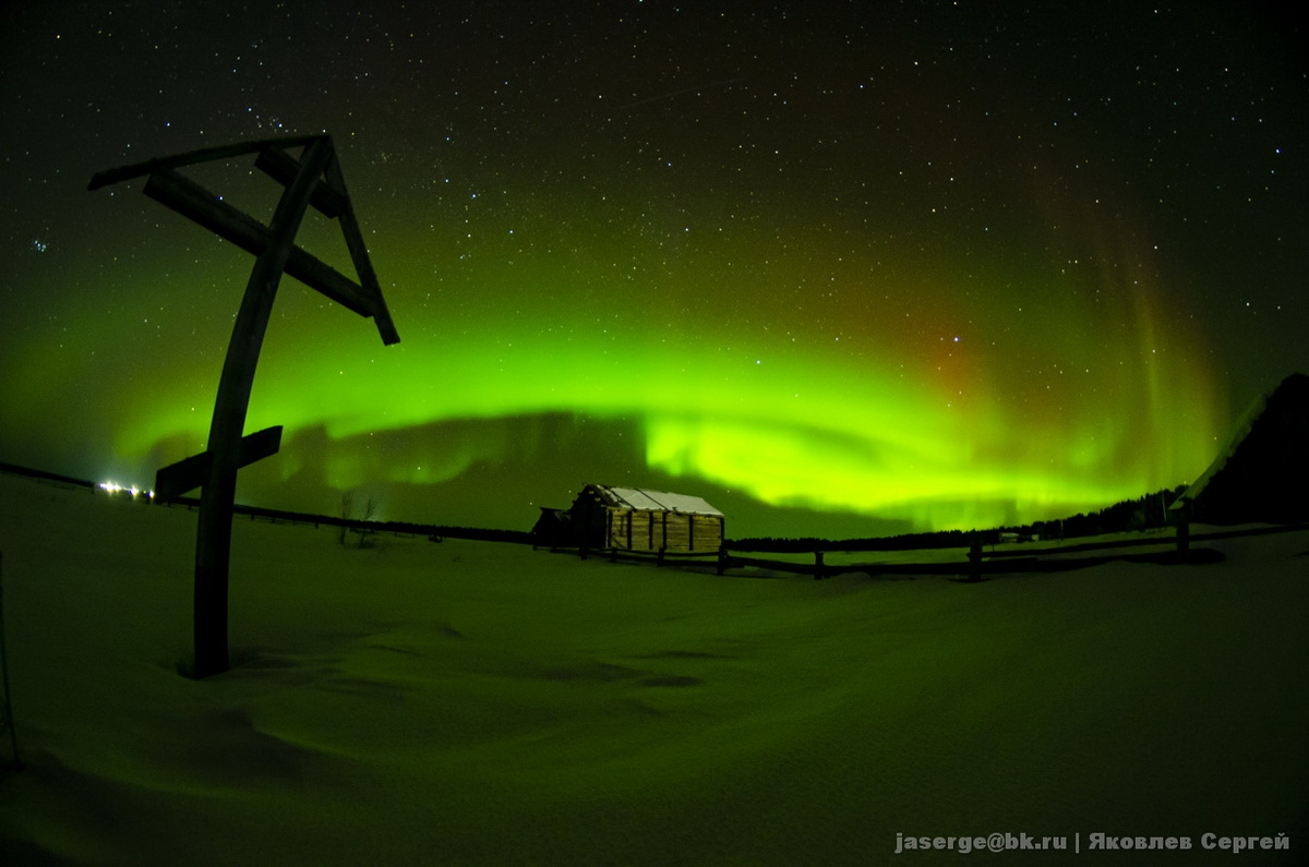 Крест в деревне Кимжа Мезенского района на фоне северного сияния