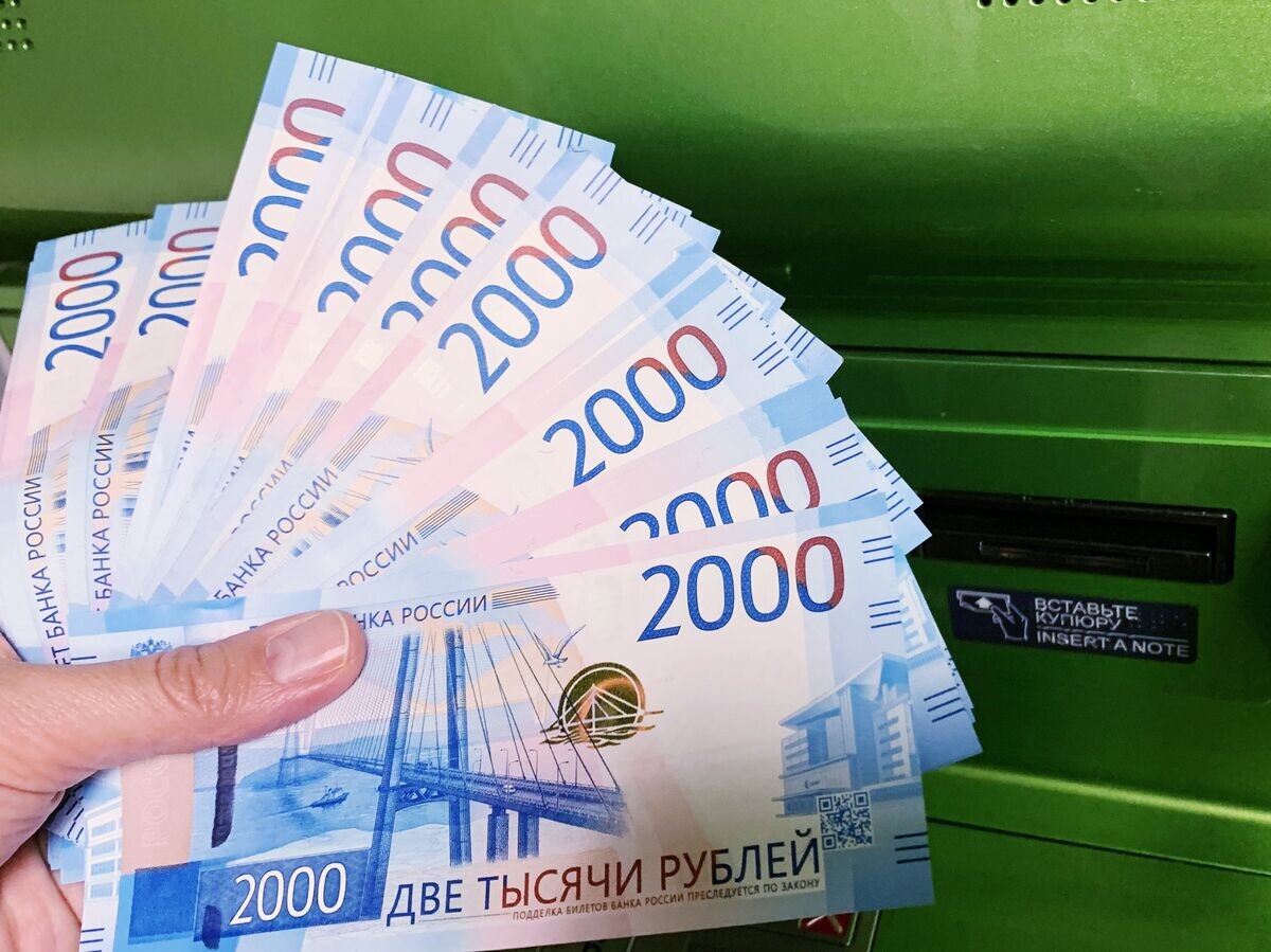    Клиент Сбербанка вносит наличные деньги в банкомат© РИА Новости . Наталья Селиверстова