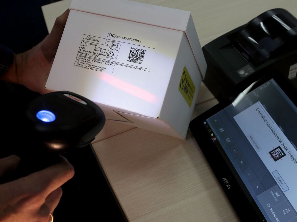    Сканер штрих-кода считывает этикетку с QR-кодом с коробки с обувью | © РИА Новости / Виталий Белоусов